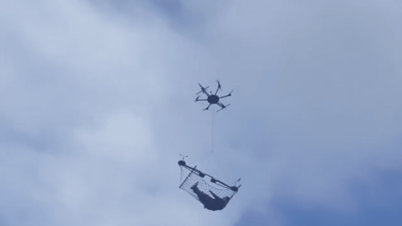 Drone carries what appears to be a man in a hammock through town